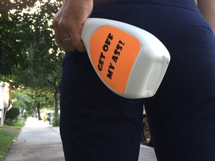 Sara Atahl walks to work at sunset with a super-sized bottle of Get Off My Ass!